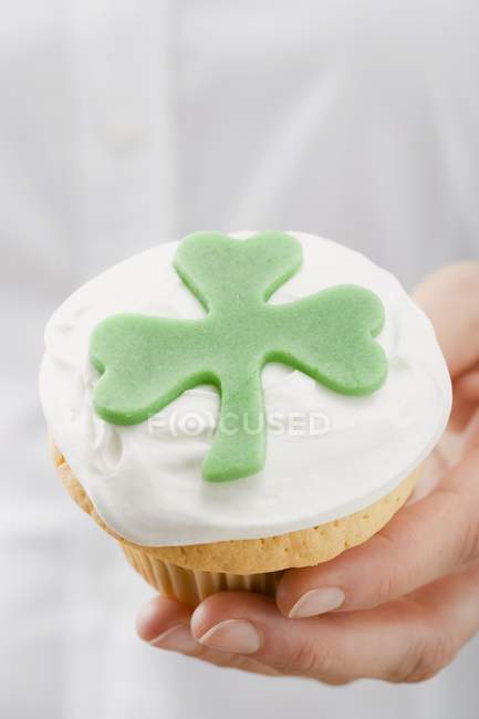 Hembra mano celebración cupcake - foto de stock