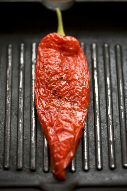 Pimenta vermelha em uma panela de ato de fritar de grade — Fotografia de Stock