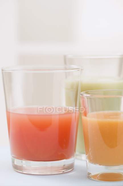 Tres jugos diferentes en vasos - foto de stock