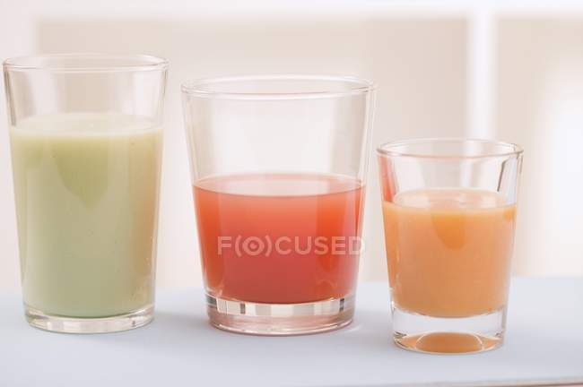 Tres jugos diferentes en vasos - foto de stock