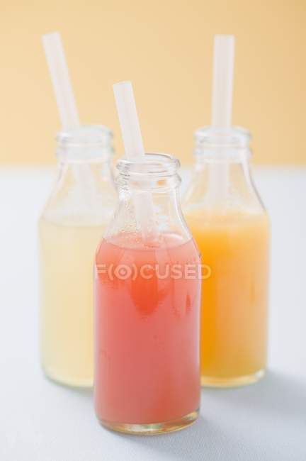 Три фруктовых сока в бутылках — стоковое фото