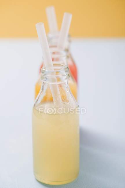 Três sucos de frutas em garrafas — Fotografia de Stock