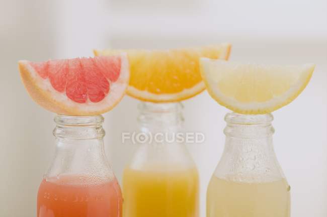 Tres zumos de frutas en botellas - foto de stock