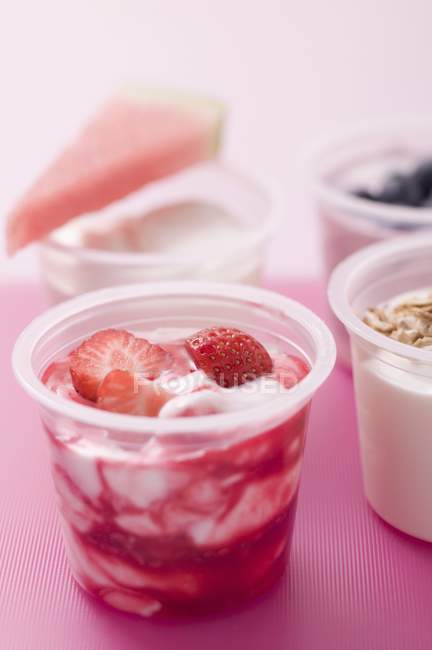 Four yoghurts with berries and cereal — Stock Photo