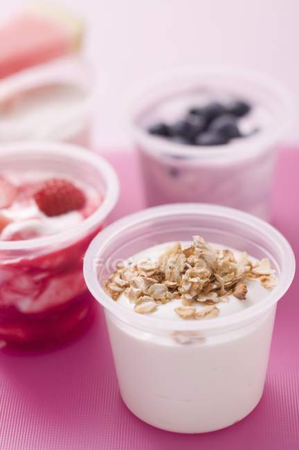 Четыре йогурта с ягодами и хлопьями — стоковое фото