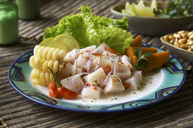 Ceviche with Corn and Sliced Yams on plate over mat — Stock Photo
