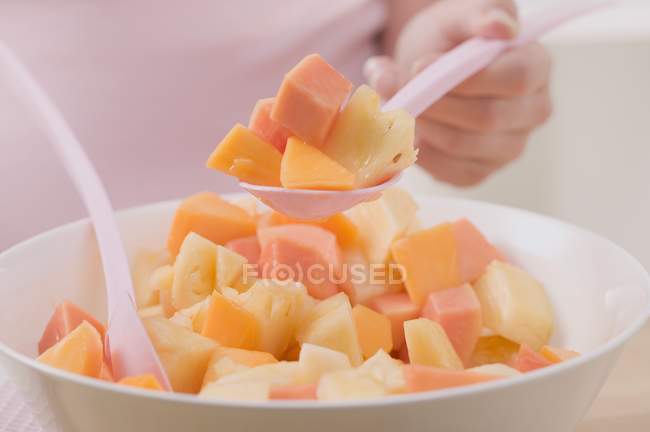 Woman taking spoonful of salad — Stock Photo