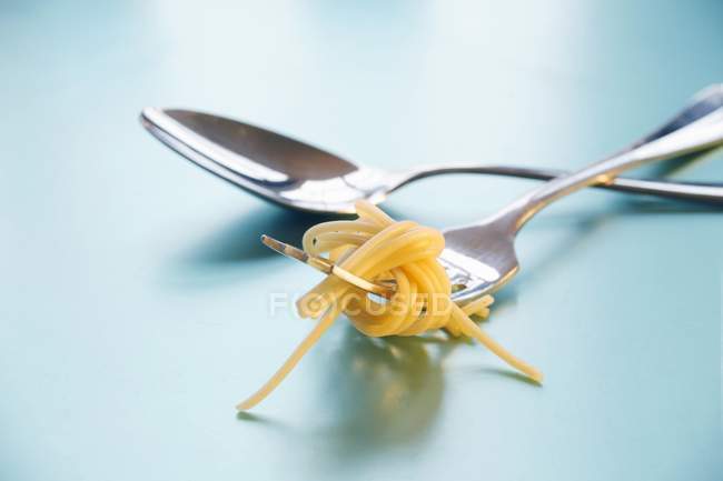 Cuchara y tenedor con espagueti - foto de stock