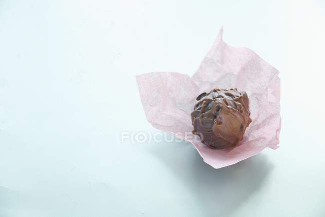 Chocolate truffle on paper — Stock Photo