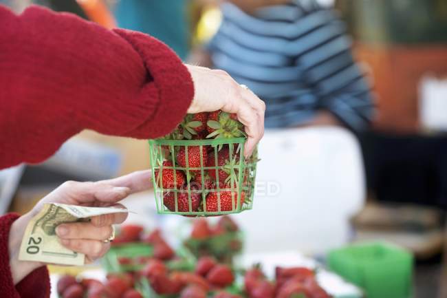 Frau kauft Erdbeeren — Stockfoto