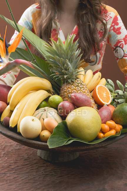 Mulher segurando tigela de frutas exóticas — Fotografia de Stock