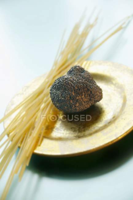 Trufa negra y espaguetis crudos - foto de stock