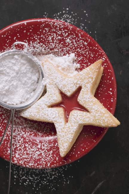 Jam biscuit on plate with icing sugar — Stock Photo