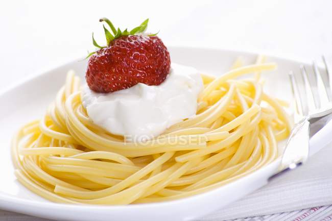 Espaguetis con queso blando y fresa - foto de stock