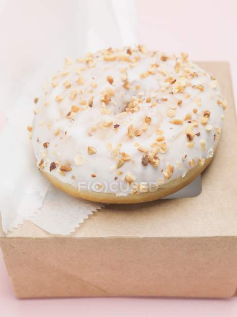 Iced doughnut with chopped nuts — Stock Photo