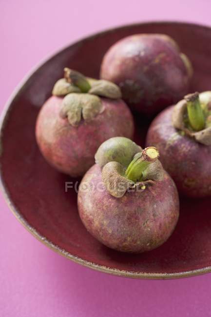 Fresh mangosteens in bowl — Stock Photo