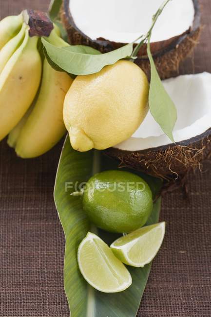 Lemon with limes and bananas — Stock Photo