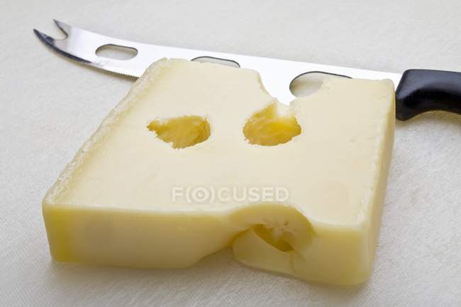 Hard cheese and knife — Stock Photo