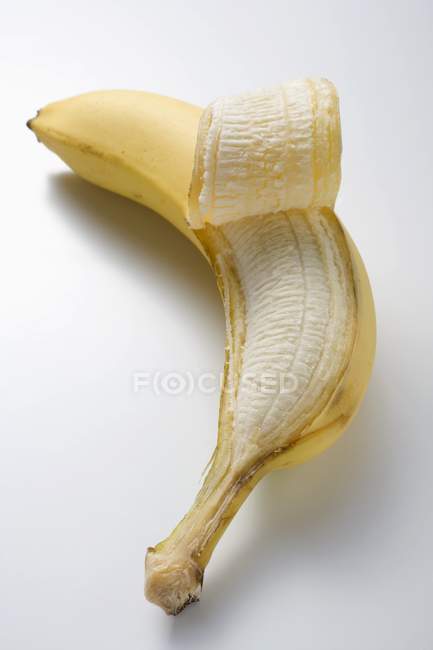 Banana fresca parcialmente descascada — Fotografia de Stock