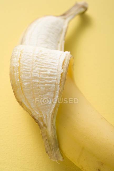 Banana fresca parcialmente descascada — Fotografia de Stock