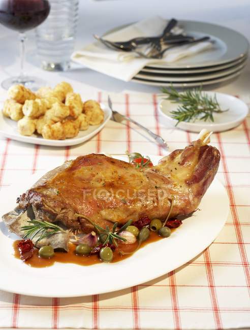 Gebratene Lammkeule mit Oliven- und Kapernsoße — Stockfoto