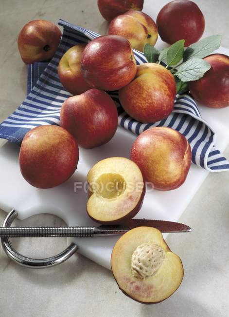 Nectarinas frescas com metades — Fotografia de Stock
