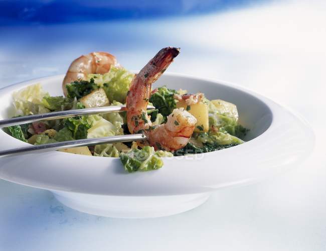 Savoy cabbage with potatoes and prawns in white bowl with chopsticks — Stock Photo