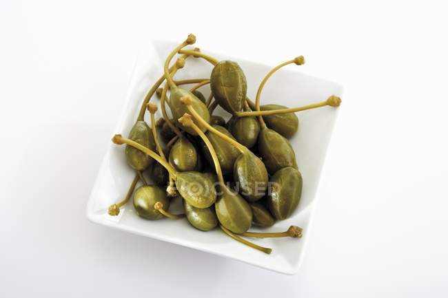 Giant capers in square dish — Stock Photo