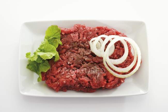 Raw minced beef with onion rings — Stock Photo