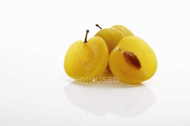 Prunes jaunes fraîches coupées en deux — Photo de stock