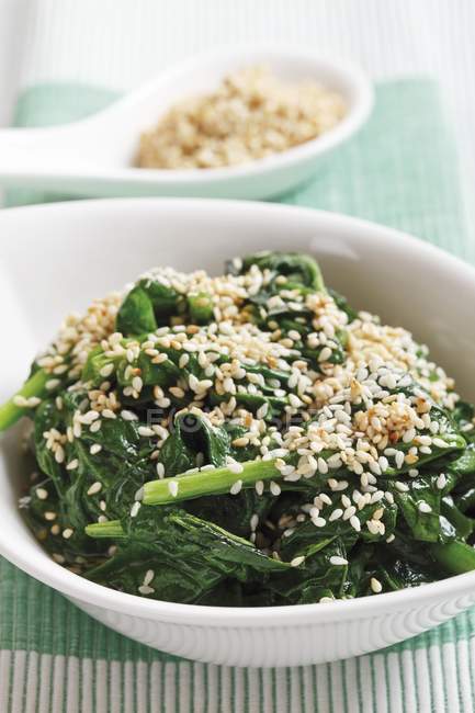 Spinach with toasted sesame seeds on white plate — Stock Photo