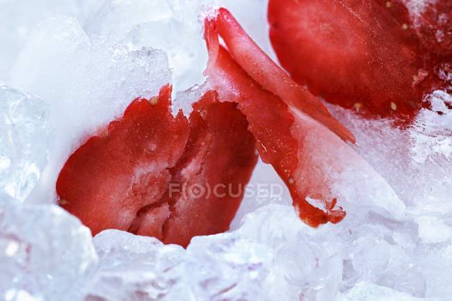 Fresa en rodajas sobre hielo - foto de stock