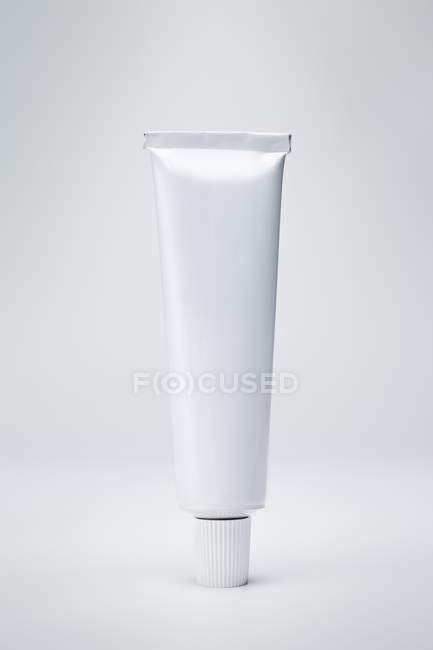 Closeup view of one metal tube on white surface — Stock Photo