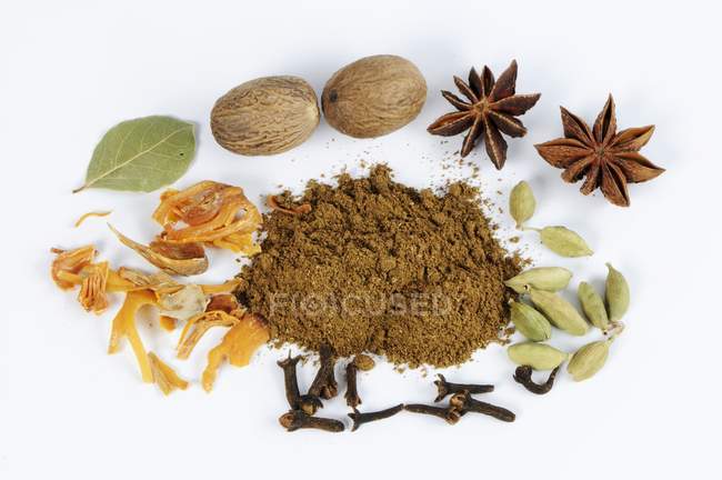 Elevated view of Garam masala surrounded by cardamom, cloves, nutmeg and star anise — Stock Photo