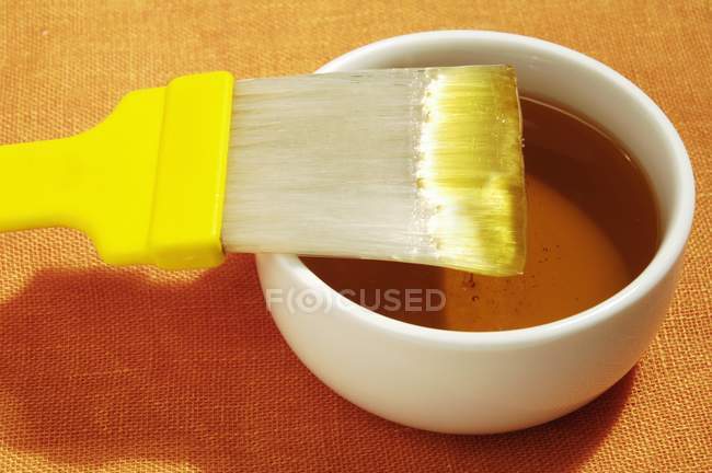 Vue rapprochée de la glaçure de sucre dans un bol avec brosse — Photo de stock