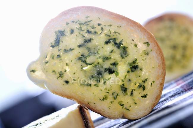 Slice of baguette with herb butter — Stock Photo