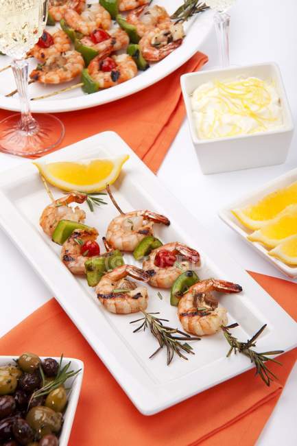 Closeup view of grilled shrimp skewers on rosemary branches by lemon Aioli — Stock Photo