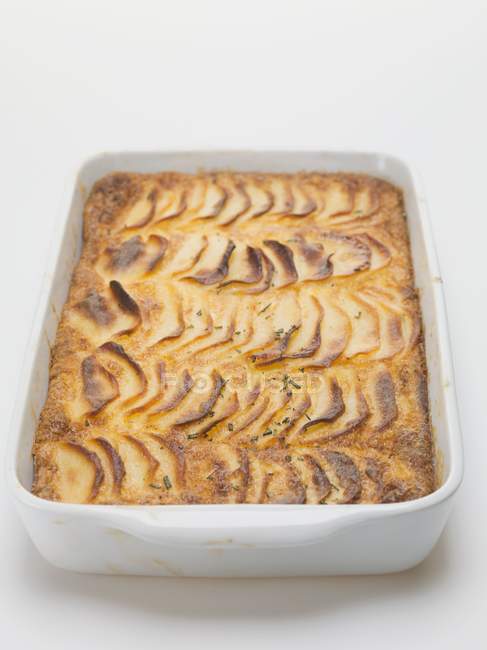 Potato gratin in baking dish on white background — Stock Photo