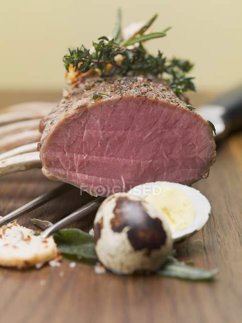 Rack of lamb with herbs and quail egg — Stock Photo