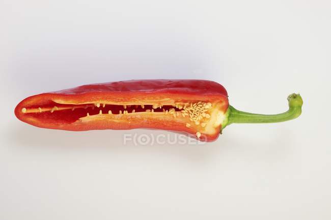 Chilli cru vermelho reduzido para metade na superfície branca — Fotografia de Stock