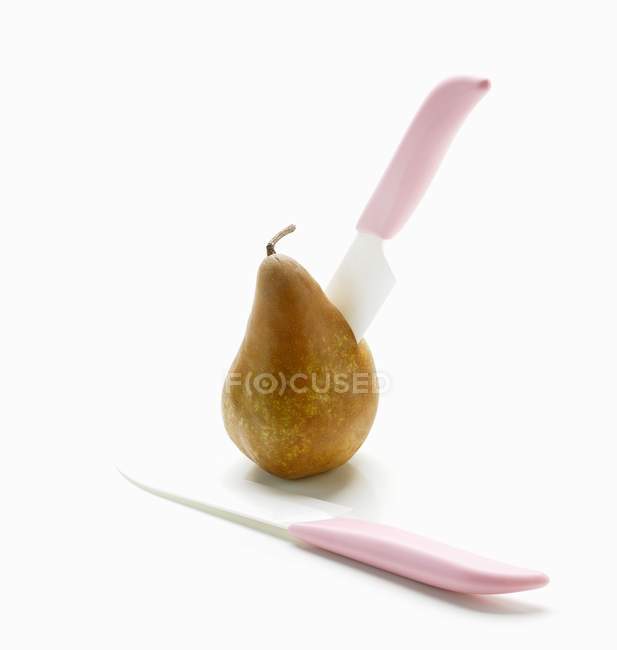 Two Pink Knives in Pear — Stock Photo