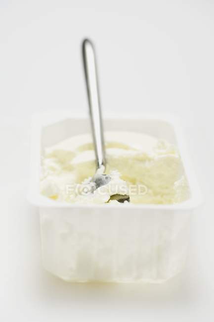 Quark con un cucchiaio in una confezione di plastica bianca — Foto stock