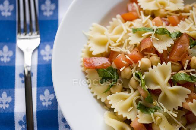 Pasta Farfalle con tomates y garbanzos - foto de stock