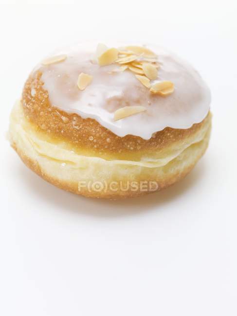 Iced doughnut with flaked almonds — Stock Photo