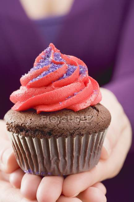 Hembra mano celebración cupcake - foto de stock