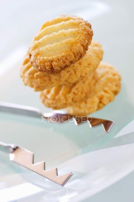 Biscotti con pinze sul piatto — Foto stock