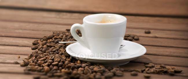 Cup of espresso and coffee beans — Stock Photo