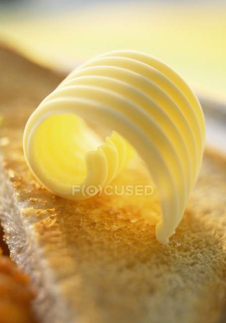 Vue rapprochée de la boucle de beurre sur le pain grillé — Photo de stock