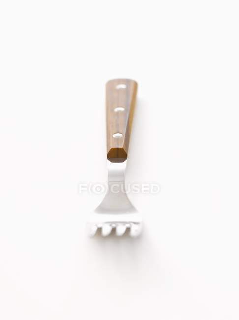 Vista close-up de um garfo com cabo de madeira na superfície branca — Fotografia de Stock