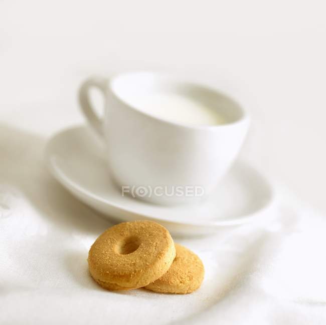 Cup of milk and biscuits — Stock Photo